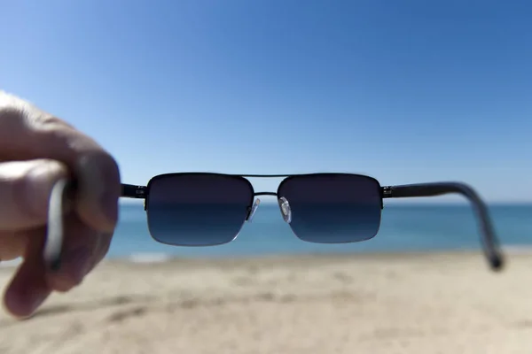 kumsalda güneş gözlüğü takan adam