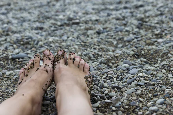 Kız sahilde denizin kenarında oturan kadın bacak görünümü