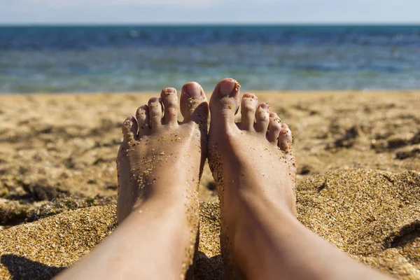 denizin kenarında plajda güneşlenirken bir kızın ayak görünümü