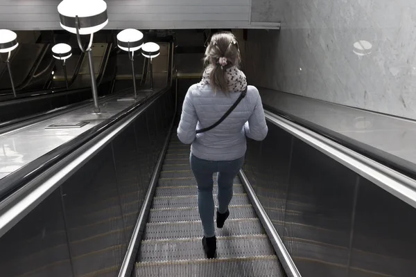 genç kız mavi ceketli bir yürüyen merdiven metro geliyor