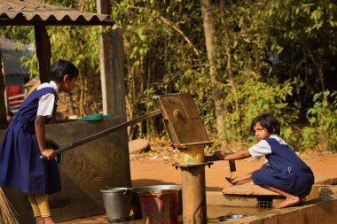 Jhargram, Batı Bengal, Hindistan - Ocak 29,2019: iki İlköğretim Okulu Kız yıkama el ve onların yemekleri bir birincil okul, Batı Bengal, gün ortası yemek çekmeden önce.