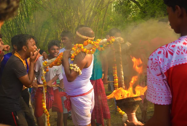 Ein Priester, der das Weihwasser zur Anbetung des Herrschers Shiva bringt. Die Dorfbewohner genießen das Programm. — Stockfoto