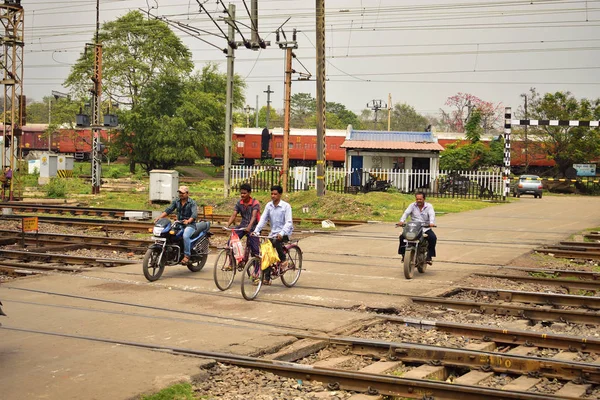 Certaines personnes traversent un passage à niveau en moto ou à vélo près de la gare de Tatanagar — Photo