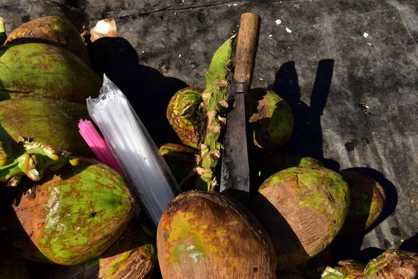 绿色椰子、塑料秸秆和椰子切割机。照片在一个迪 — 图库照片