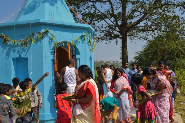 Sommige mannen en vrouwen die Puja-rituelen uitvoeren door rond de tempel te lopen en snoep te verdelen over de kinderen. — Stockfoto