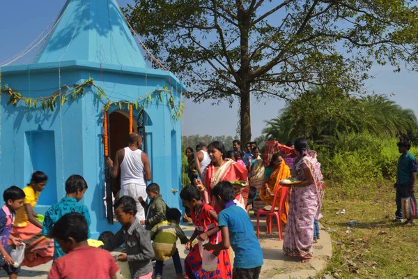Quelques hommes et femmes accomplissant des rituels de puja en marchant autour du temple et en distribuant des bonbons aux enfants . — Photo