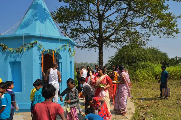 Sommige mannen en vrouwen die Puja-rituelen uitvoeren door rond de tempel te lopen en snoep te verdelen over de kinderen. — Stockfoto