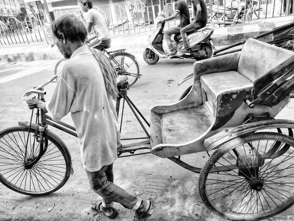 Jhargram, Bengala Occidental, India - 05 de mayo de 2019: Imagen en blanco y negro de Un rickshwa tirado a mano fue tirado por alguien en una carretera concurrida de una ciudad en Bengala Occidental — Foto de Stock