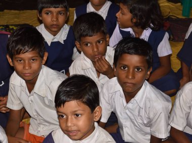 Okul öğrencileri okulda, dışarıda, gruplar halinde, üniformalı. Devlet okulunda.