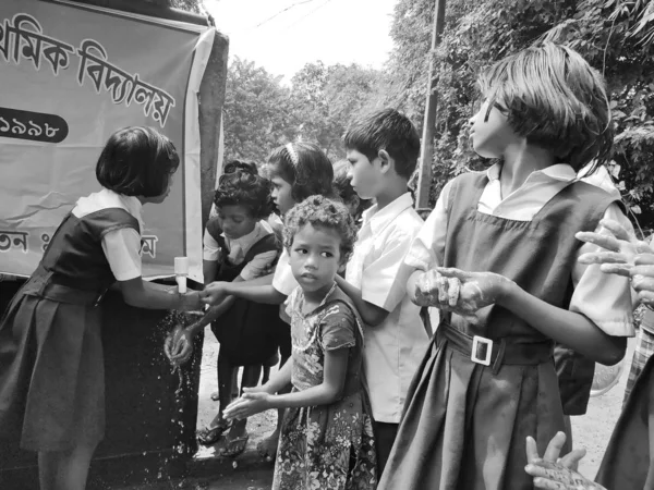 Általános iskolások mossák a kezüket és az edényeiket, mielőtt egy nyugat-bengáli általános iskolában félnapos étkezést vennének be.. — Stock Fotó