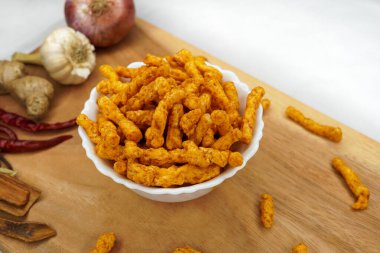 Bir kase ev yapımı patates cipsi. Beyaz arka planda pirinç, hardal, biberiye, fleur, tuz, soğan ve biberden yapılmış. Hint çayı atıştırmalıkları, güzel kavramları. Üst Manzara. Boşluğu kopyala