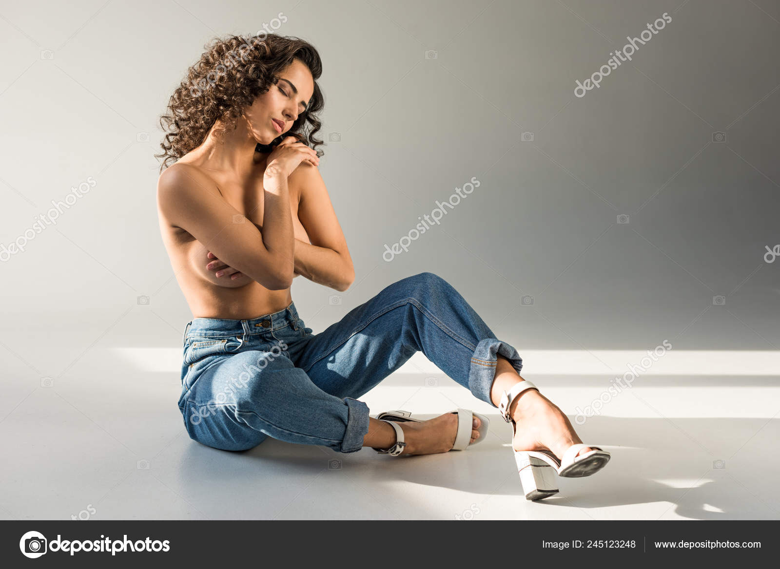 Tender Naked Woman Curly Hair Covering Breast Hand While Sitting Stock  Photo by ©DmitriyAnaniev 245123248