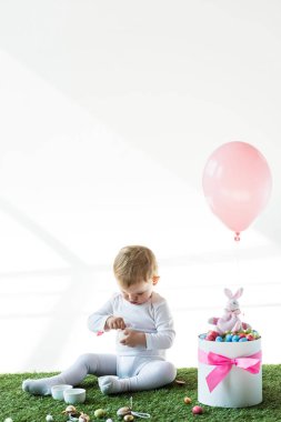 sevimli bebek renkli bıldırcın yumurtaları, Dekoratif tavşan ve beyaz üzerinde izole hava balonu ile kutu yakın oturan