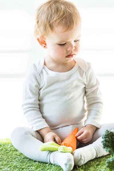 Cute Dreamy Kid Sitting Green Grass Holding Toy Carrot White — Stock Photo, Image