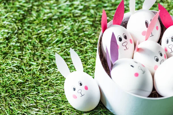 Chicken eggs with drawn rabbit faces and paper ears on green grass surface — Stock Image Chicken Eggs Drawn Rabbit Faces Paper Ears Green Grass Surface Royalty Free Stock Photos