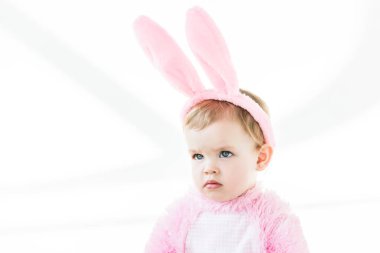 adorable pensive baby in bunny ears headband looking away isolated on white clipart