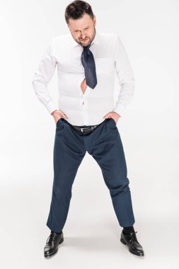 overweight man in tight formal wear with hands in pockets posing on white clipart