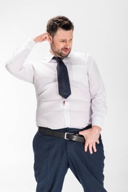 kemer üzerinde el ile sıkı resmi giyim kilolu adam beyaz izole poz