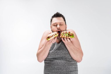 beyaz izole sosisli sandviç yiyen kilolu adam