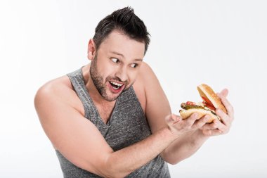 beyaz izole burger tutan tank top içinde gülümseyen kilolu adam