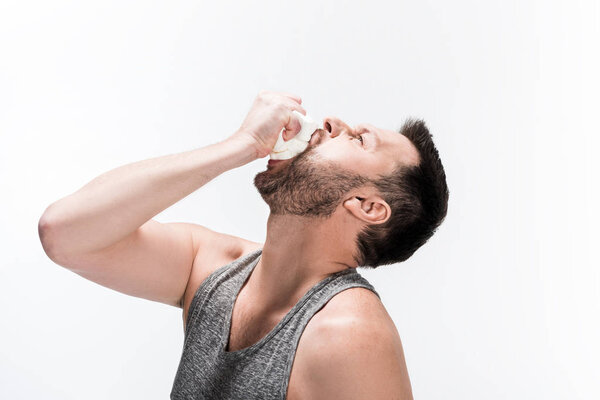 chubby man in tank top eating marshmallows isolated on white