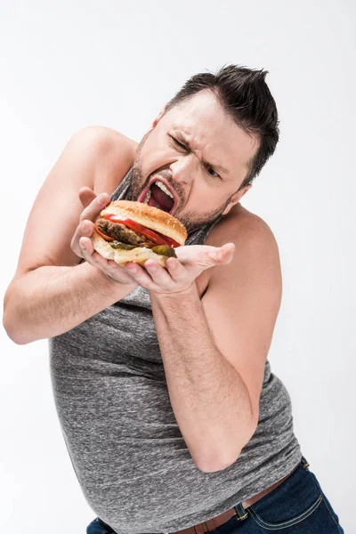 Homem Com Sobrepeso Fazendo Expressão Facial Enquanto Posando Com Hambúrguer — Fotografia de Stock