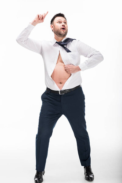 excited overweight man in tight formal wear pointing with finger isolated on white