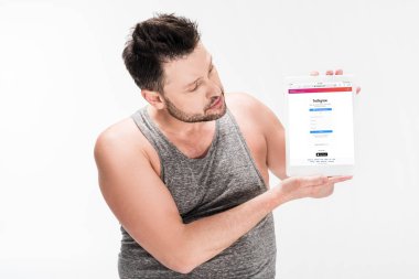 beyaz izole ekranda instagram uygulaması ile dijital tablet gösteren kilolu adam