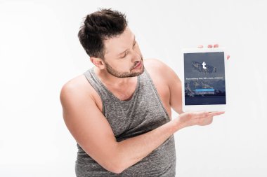 beyaz izole ekranda tumblr uygulaması ile dijital tablet gösteren kilolu adam