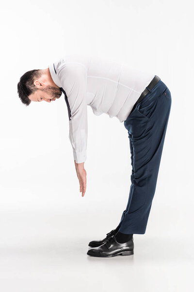 overweight man in tight formal wear bending over and stretching on white