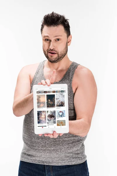 과체중 남자는 카메라를보고 흰색에 화면에 핀터레스트 프로그램과 디지털 태블릿을 보여주는 — 스톡 사진