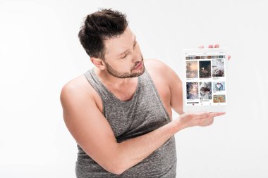 beyaz izole ekranda pinterest uygulaması ile dijital tablet gösteren kilolu adam