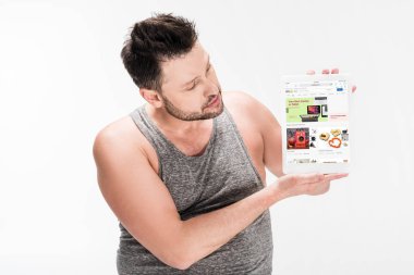 beyaz izole ekranda ebay uygulaması ile dijital tablet gösteren kilolu adam