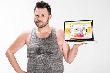 kilolu adam kamera bakıyor ve ekranda aliexpress web sitesi ile dizüstü bilgisayar tutarak beyaz izole