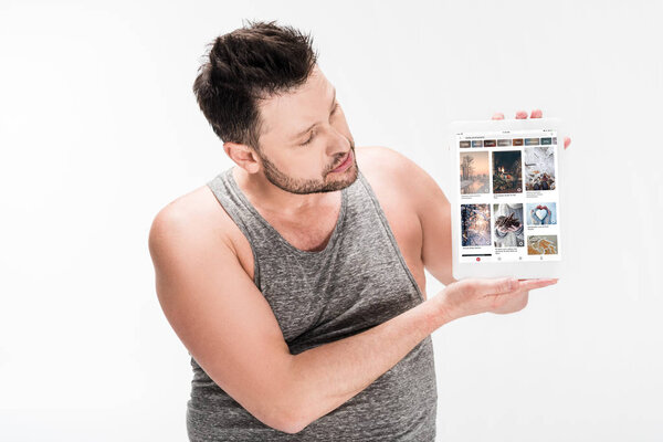 overweight man showing digital tablet with pinterest app on screen isolated on white