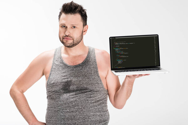 overweight man looking at camera and holding laptop with microsoft windows software on screen isolated on white