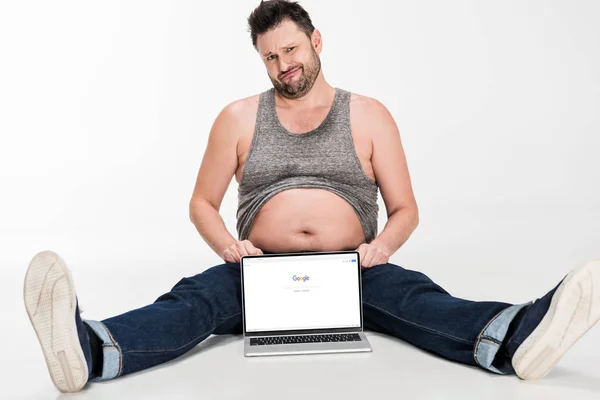 Sceptische Overgewicht Man Het Maken Van Gezichtsuitdrukking Zittend Met Laptop — Stockfoto