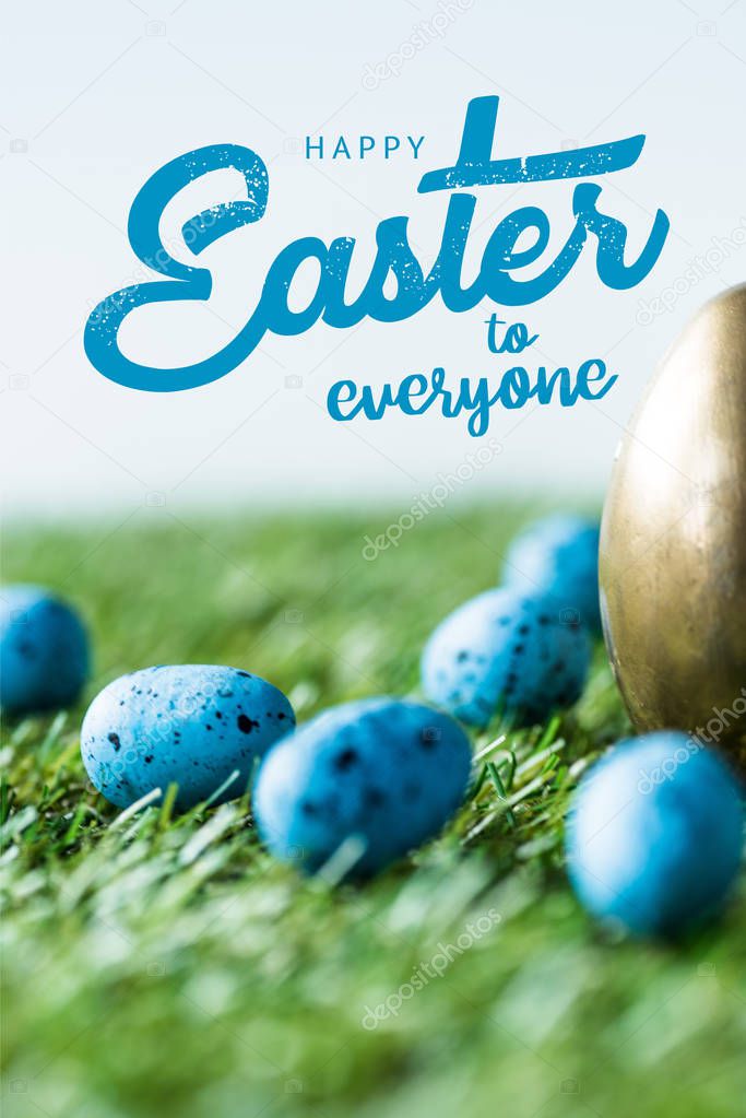 blue painted quail eggs on green grass near golden chicken egg and happy Easter to everyone lettering