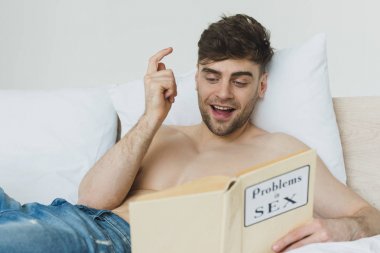 mavi kot yakışıklı gömleksiz adam seks kitabında sorunları okuma ve fikir işareti gösteren