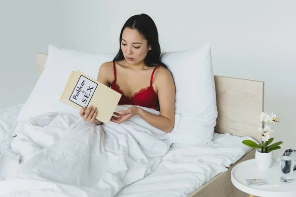 Pensativo Asiático Mulher Vermelho Lingerie Segurando Problemas Sexo Livro Enquanto — Fotografia de Stock