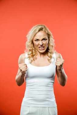 kızgın sarışın kadın kameraya bakıyor ve kırmızı yumruklar gösteren 