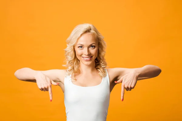 Aantrekkelijke Vrouw Kijkt Naar Camera Wijst Met Vingers Geïsoleerd Oranje — Stockfoto