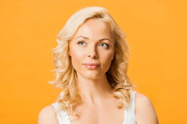 Mooie Peinzende Blonde Vrouw Denken Geïsoleerd Oranje — Stockfoto