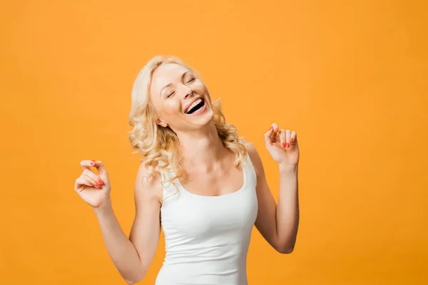 Vrolijke Blonde Vrouw Met Gesloten Ogen Glimlachend Geïsoleerd Oranje — Stockfoto