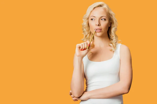 Pensive Blonde Woman Holding Pencil Mouth While Thinking Isolated Orange — Stock Photo, Image