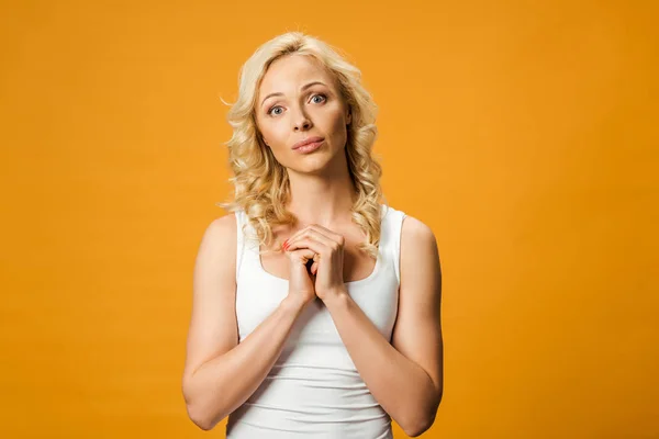 Pretty Curly Woman Looking Camera Standing Clenched Hands Isolated Orange — Stock Photo, Image