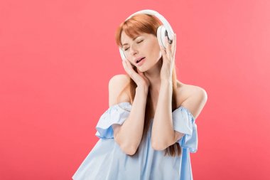 pembe izole kapalı gözleri ile kulaklık müzik dinle çekici kızıl saçlı kadın