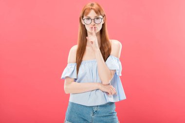 gözlük redhead kız ön görünümü kameraya bakarak ve pembe izole sus işareti gösteren