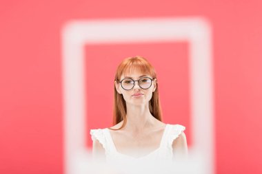 Kiev, Ukrayna-Mayıs 23, 2019: Vintage kamera çerçevesi arkasında ayakta gözlüklü Redhead kız seçici odak pembe izole