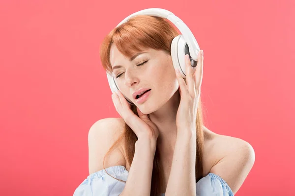 Привлекательная Рыжая Женщина Слушает Музыку Наушниках Закрытыми Глазами Изолированными Розовый — стоковое фото